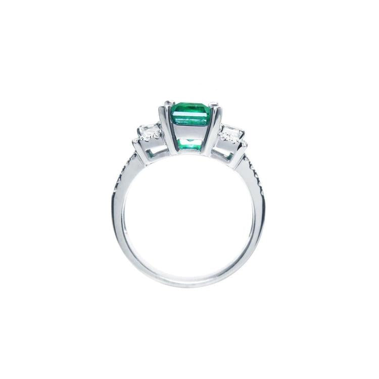 1.88 carat emerald ring with side emerald-cut diamonds and round accents in 18k white gold.