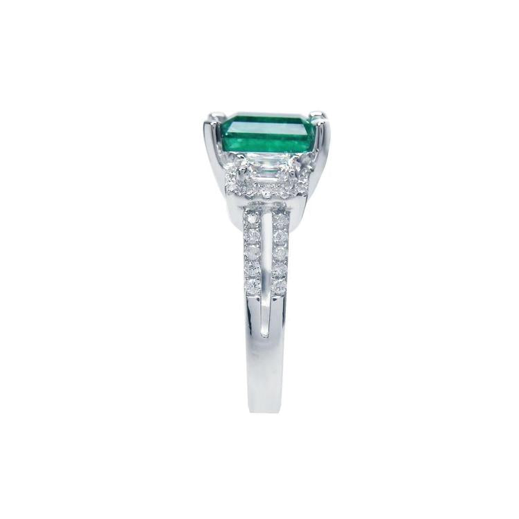 1.88 carat emerald ring with side emerald-cut diamonds and round diamonds set in 18k white gold.
