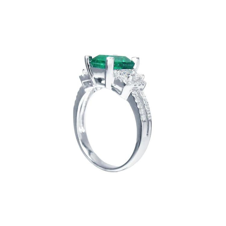 1.88 carat emerald ring with side emerald-cut and round diamonds in 18k white gold.