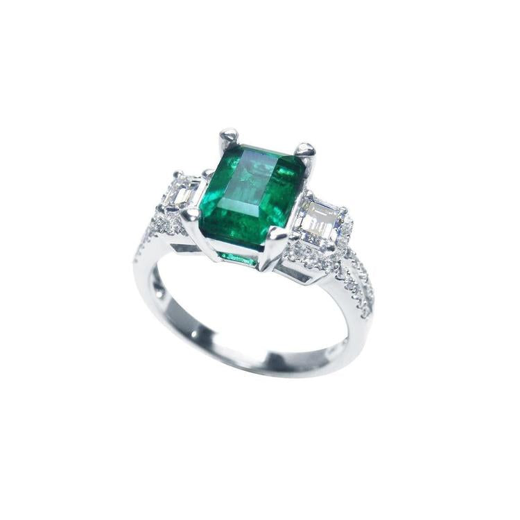 1.88 carat emerald ring with side emerald-cut and round diamonds in 18k white gold.