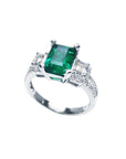 1.88 carat emerald ring with side emerald-cut and round diamonds in 18k white gold.