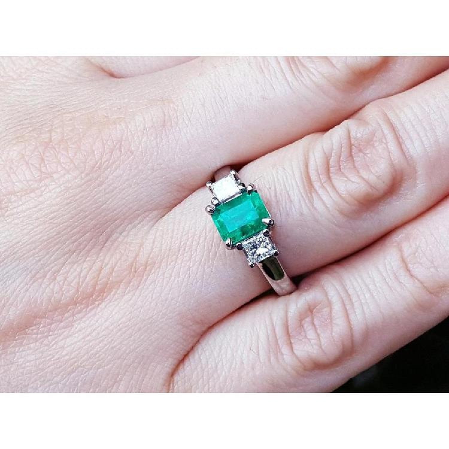 1.38 ct. Colombian emerald ring with two princess cut side diamonds in 18k white gold.