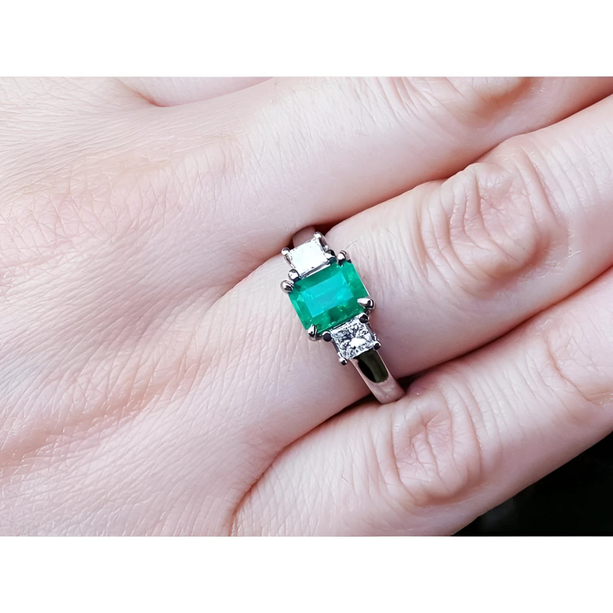 1.38 ct. Colombian emerald ring with two princess cut side diamonds in 18k white gold.