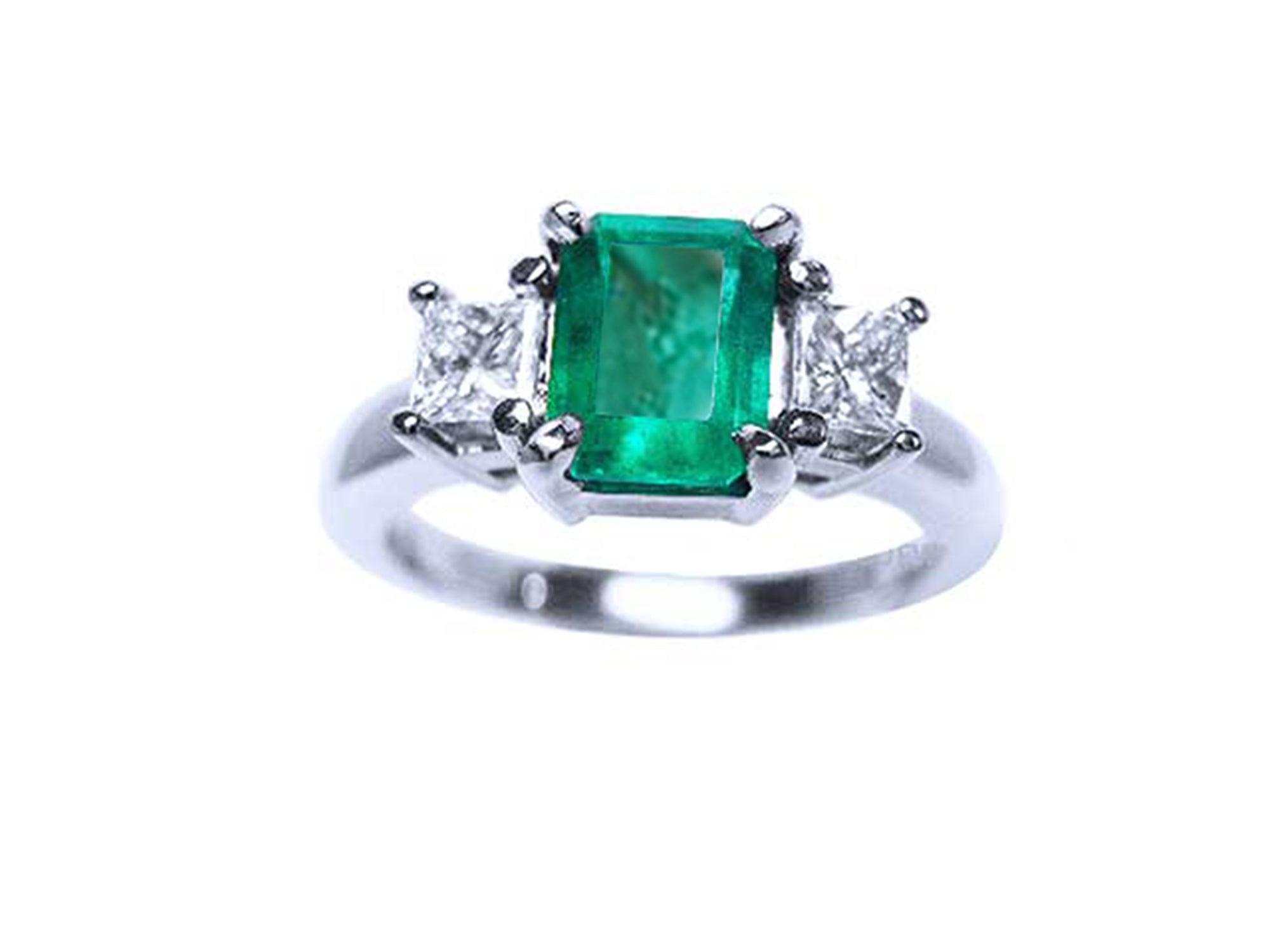 A top view of a three stone natural emerald ring with princess cut side diamonds in white gold.