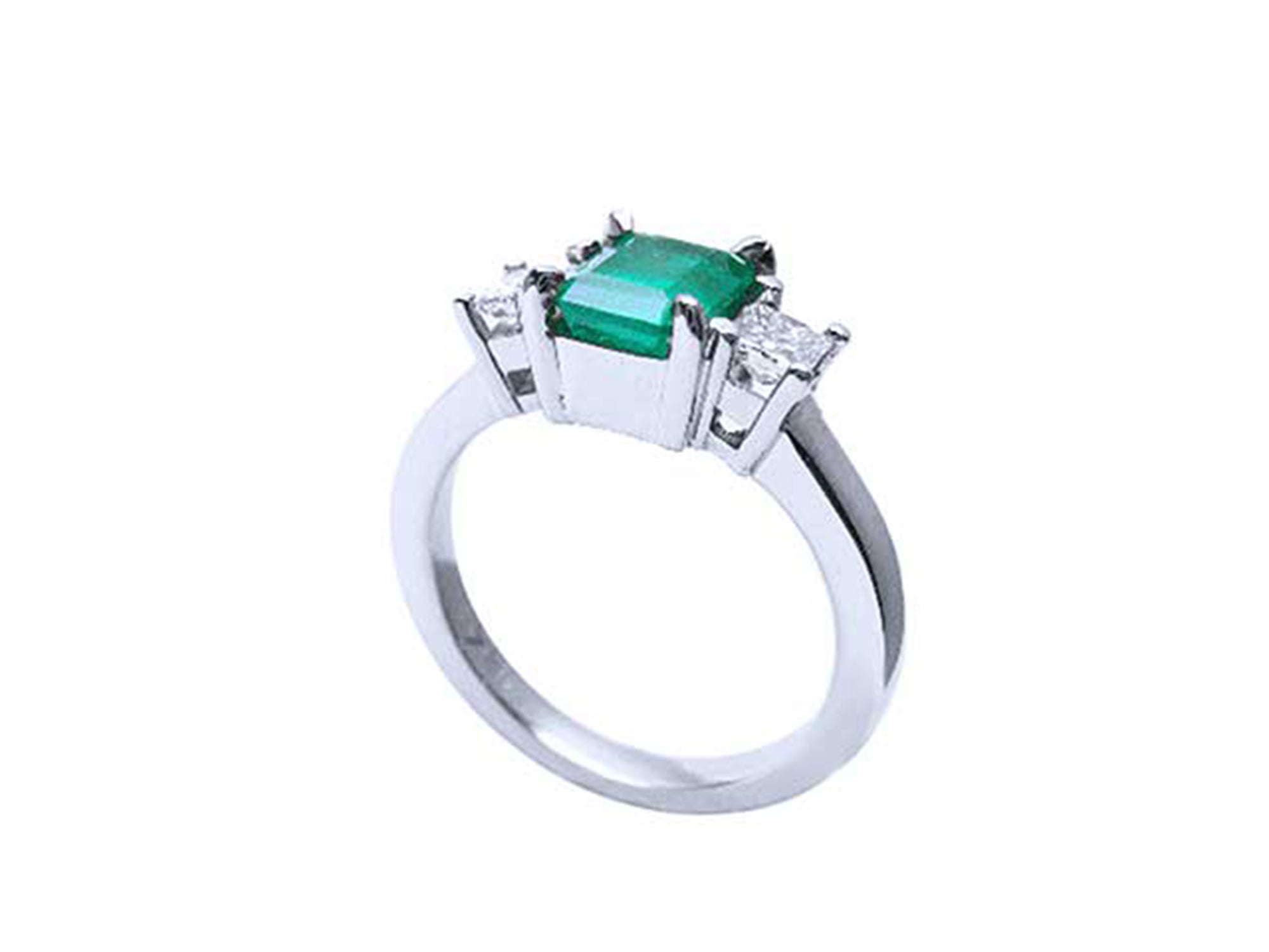 Side profile of a white gold three stone emerald ring.