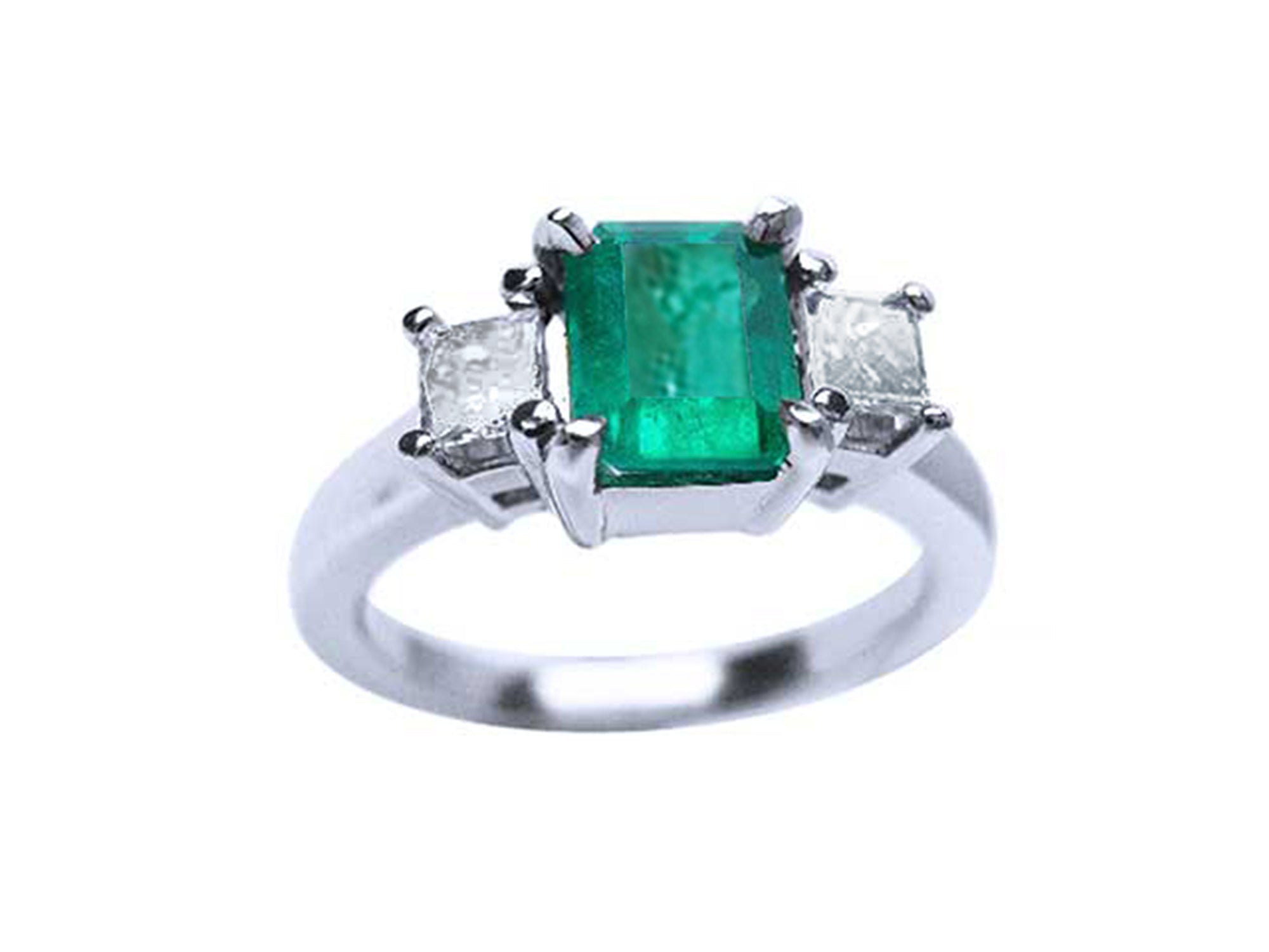 White gold emerald three stone ring on a white background.