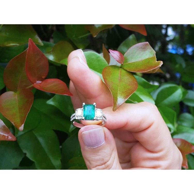 1.88 carat emerald ring with side emerald-cut diamonds and round accents in 18k white gold.