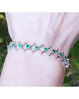 Emerald bracelet for women round cut natural Colombian emeralds crafted in 14k white gold.