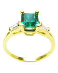 A natural emerald with side baguettes diamond ring yellow gold, topside and lateral profile view.