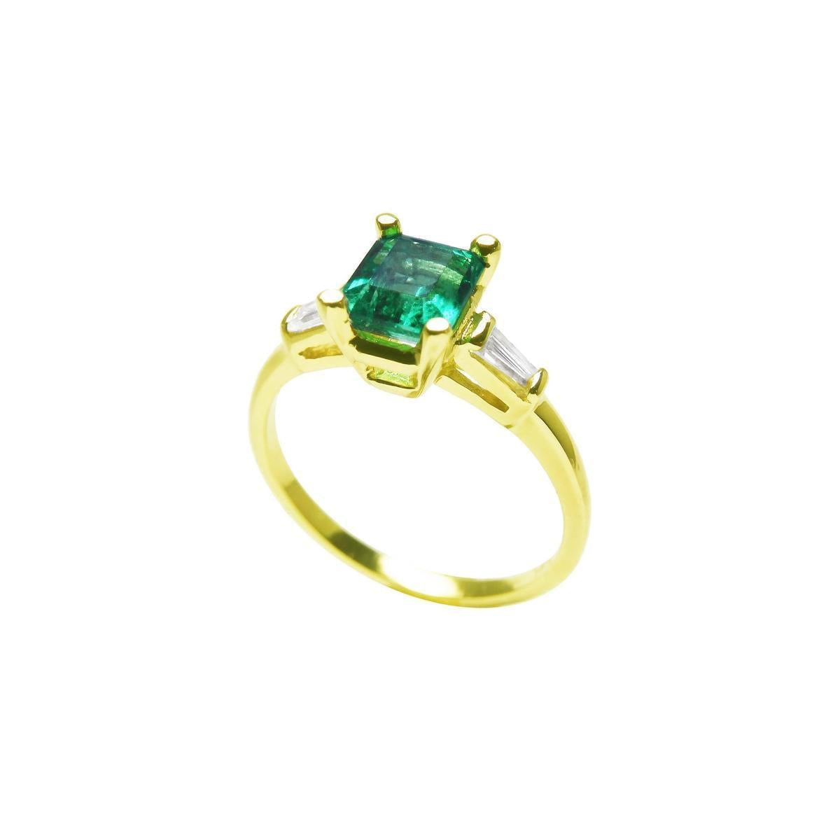 A profile view on top a square emerald and side baguette diamond ring. 