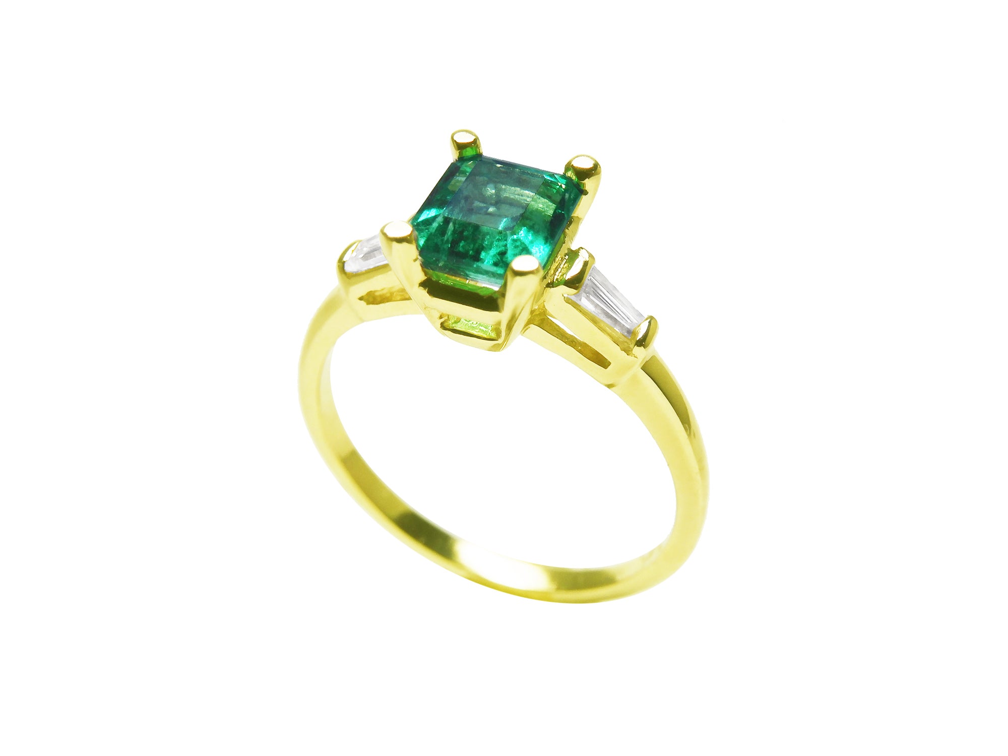 A profile view on top a square emerald and side baguette diamond ring. 
