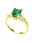 A profile view on top a square emerald and side baguette diamond ring. 