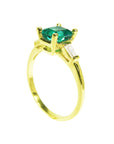Side view of a yellow gold emerald and side baguette diamond ring