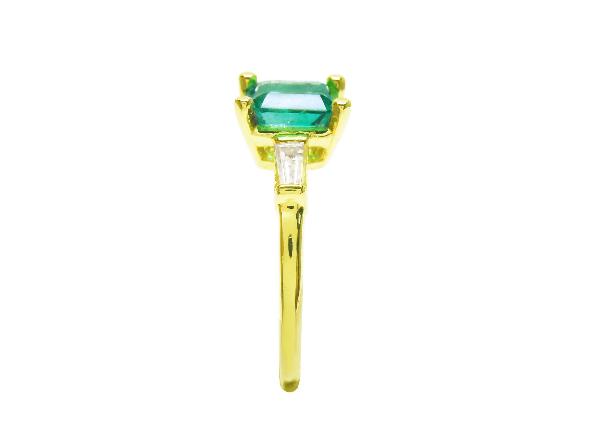 This yellow gold emerald ring shows its side profile, on top the square emerald, baguette diamond and band ring downside.