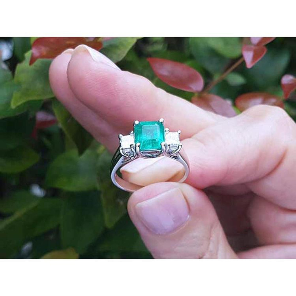 1.62 carat emerald engagement ring with side princess cut diamonds in 14k white gold.