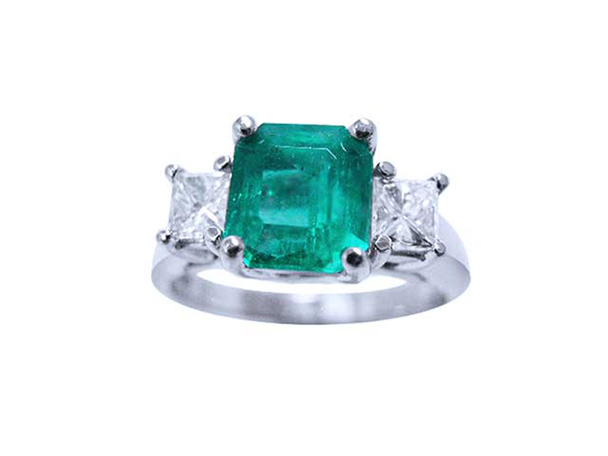 A top side view of an emerald and princess cut side diamonds ring in white gold.