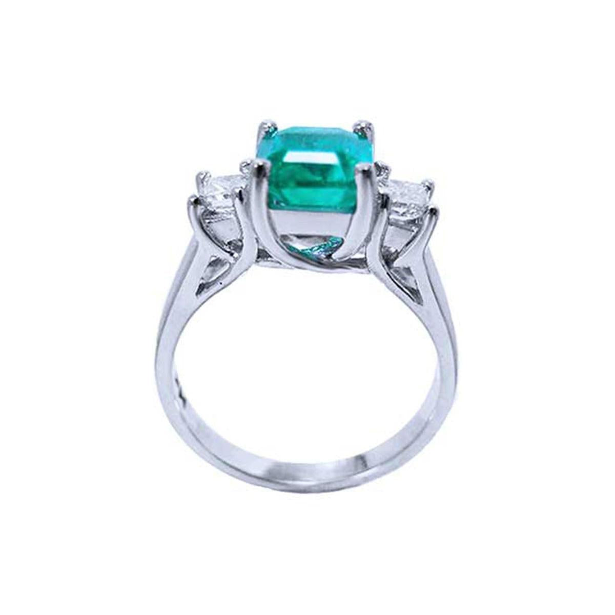 A natural emerald and diamond side princess cut ring on a lateral position, top and gallery profile view.