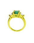 18k gold ring with a 1.51 ct. emerald and two trillion-cut side diamonds.