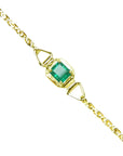 The topside view of a square emerald solitaire bracelet prong set in 14k yellow gold.