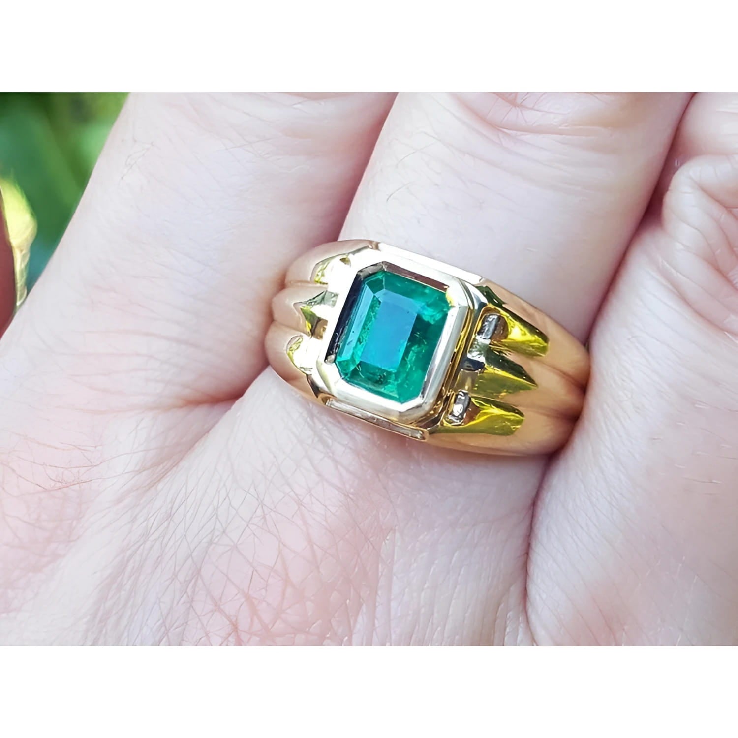 Men's 14K yellow gold solitaire ring with a bezel-set, deep green Colombian emerald.