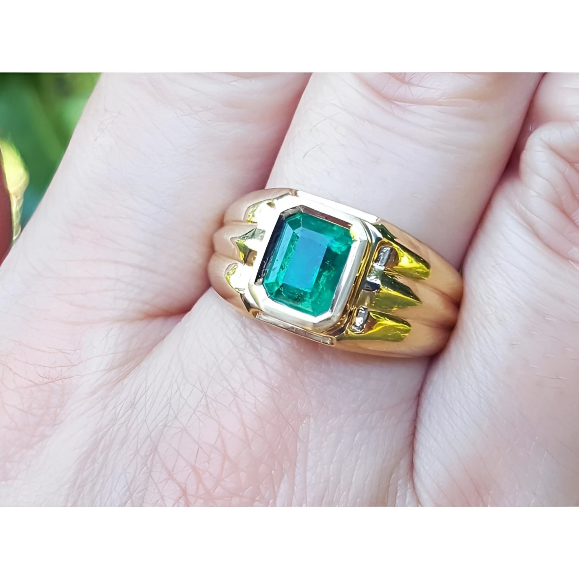 Men's 14K yellow gold solitaire ring with a bezel-set, deep green Colombian emerald.
