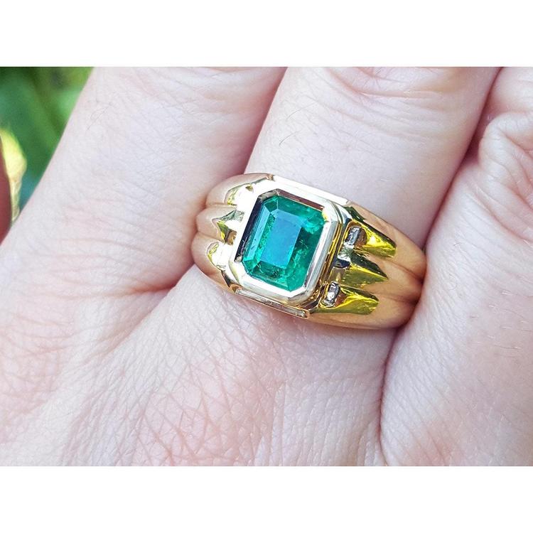Men's 14K yellow gold solitaire ring with a bezel-set, deep green Colombian emerald.