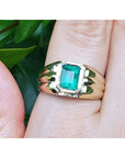 14k gold solitaire ring for men with a natural colombian emerald bezel set worn on a hand.