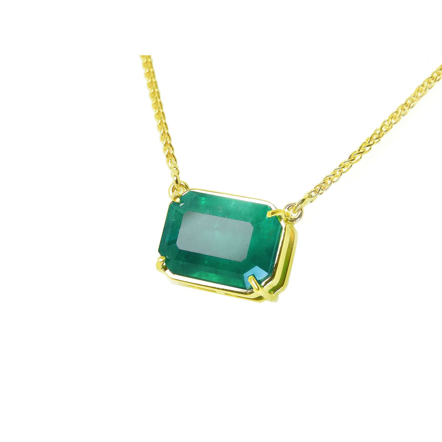 Emerald-cut Colombian emerald solitaire necklace in 18K yellow gold.