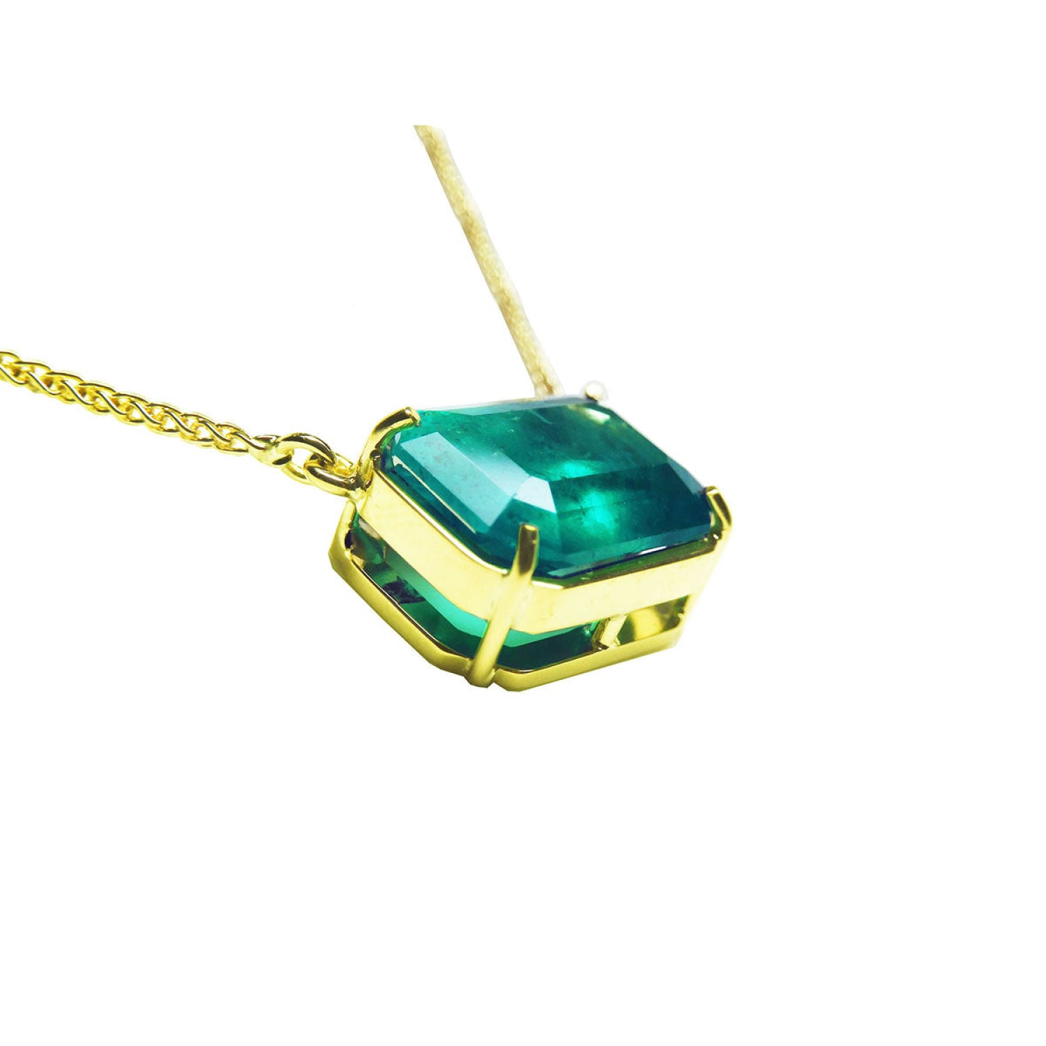 Emerald-cut Colombian emerald solitaire necklace in 18K yellow gold.