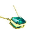 Emerald-cut Colombian emerald solitaire necklace in 18K yellow gold.