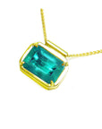 Natural Muzo Colombian emerald solitaire in 18K yellow gold, east-west orientation.