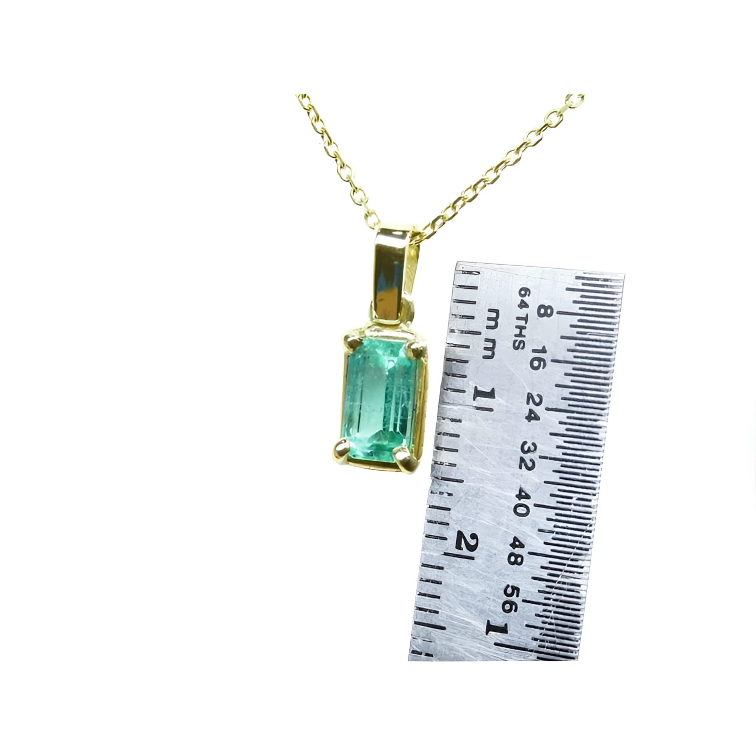 1.31 ct emerald solitaire pendant in 14K yellow gold with a ruler for scale.