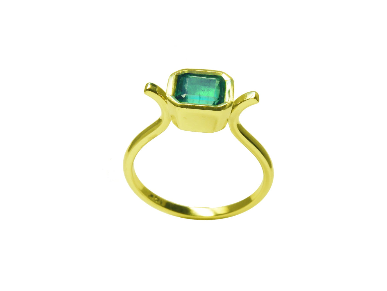 A partial profile of a solitaire emerald ring bezel set in yellow gold.