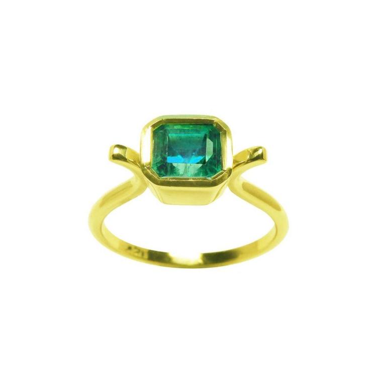 A solitaire natural colombian emerald ring bezel set in 14k yellow gold.