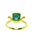 A solitaire natural colombian emerald ring bezel set in 14k yellow gold.
