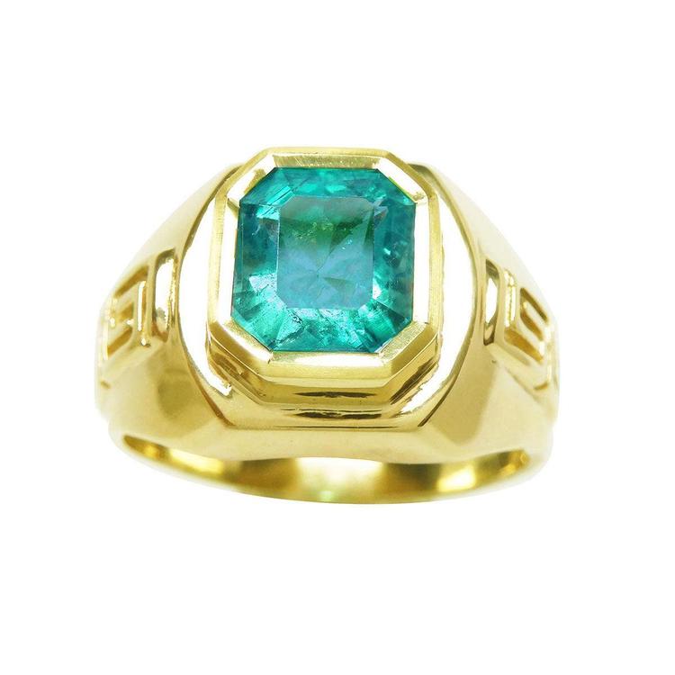 A 14k yellow gold men's emerald solitaire ring bezel set with side Greek decoration. 