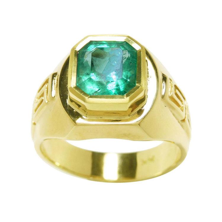 A natural men's colombian emerald ring displaying a topside position and sideways perspective.