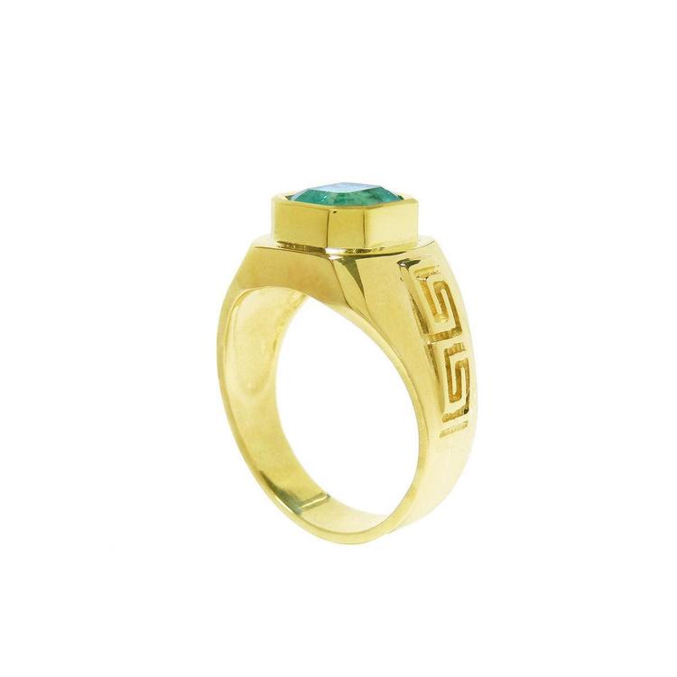 A men's emerald ring displaying its top bezel setting and partial side profile.