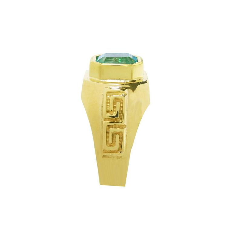 Side view of a men's natural emerald ring displaying its top setting and side band design Greek decoration.