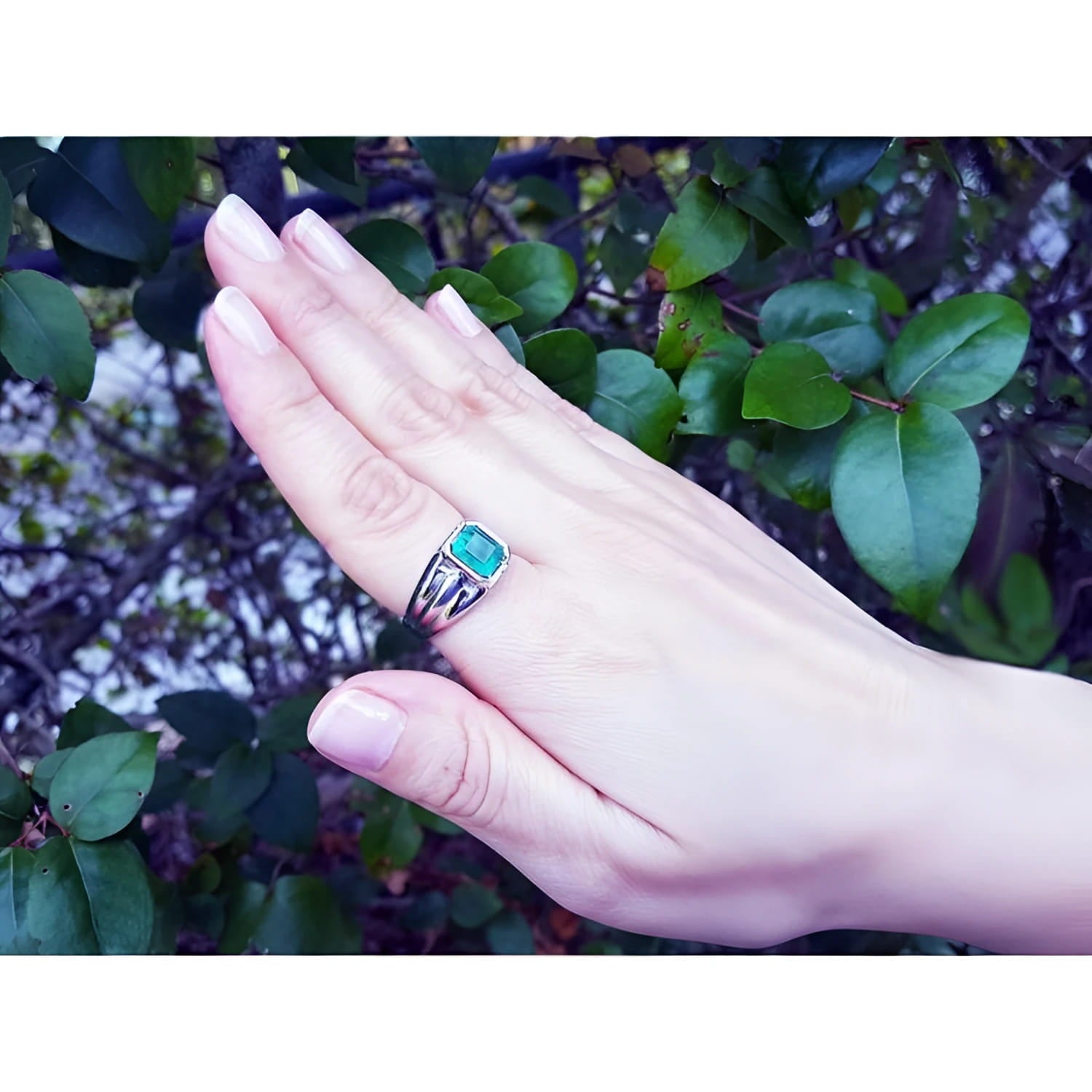 Men's 18K white gold ring with a bezel-set, rectangular Muzo emerald solitaire.