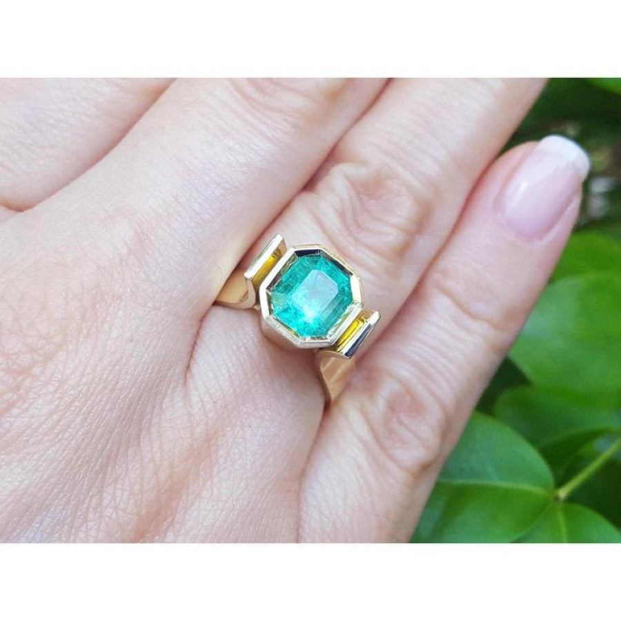 2.14 ct. rectangular emerald-cut Colombian emerald bezel set in a 14K yellow gold solitaire ring.