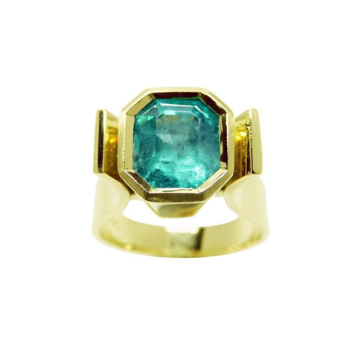 Emerald solitaire ring for women bezel set in 14k yellow gold.