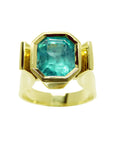 A top view of this emerald solitaire ring for women in bezel set.