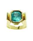 Colombian emerald solitaire ring for women bezel set in 14k yellow gold.