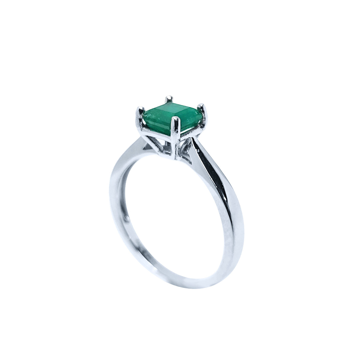 The half side profile view of a silver solitaire ring with a genuine emerald on a white background