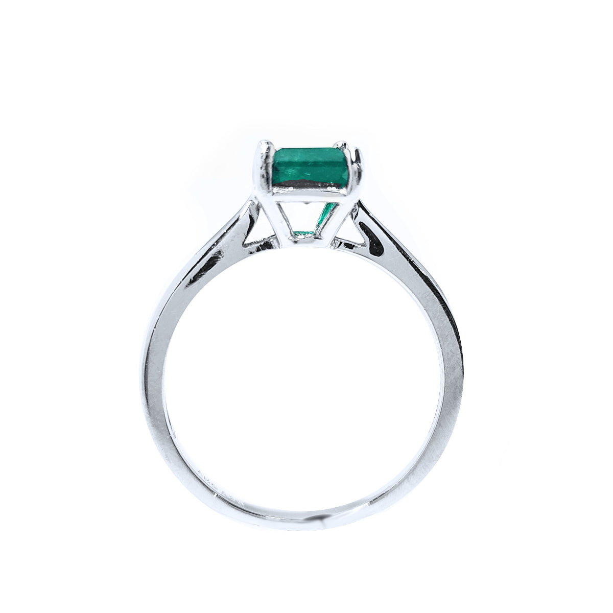 A lateral view of a solitaire sterling silver ring with a natural colombian emerald on a white background