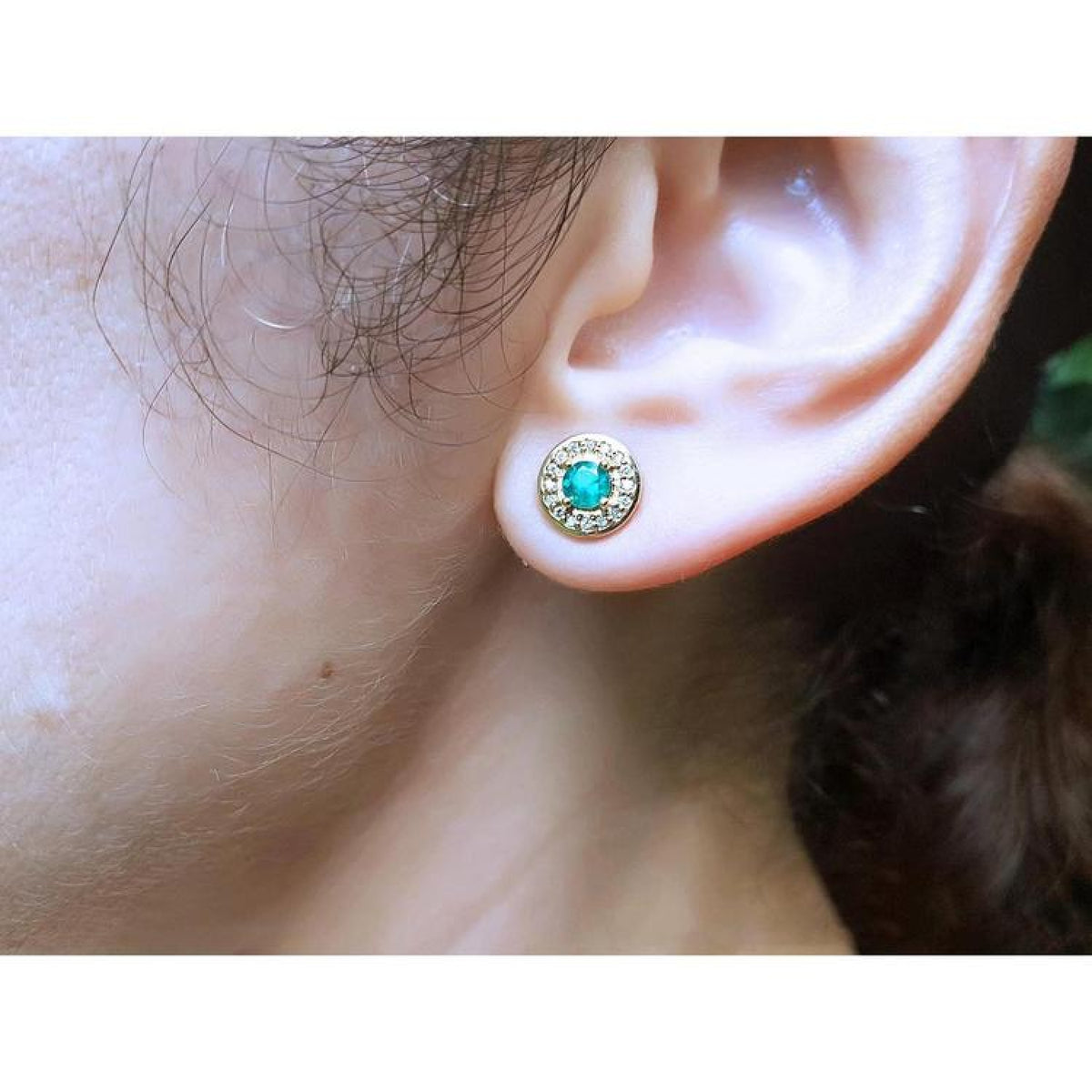 14k yellow gold emerald halo stud earring with round deep bluish-green emerald and diamond accents.