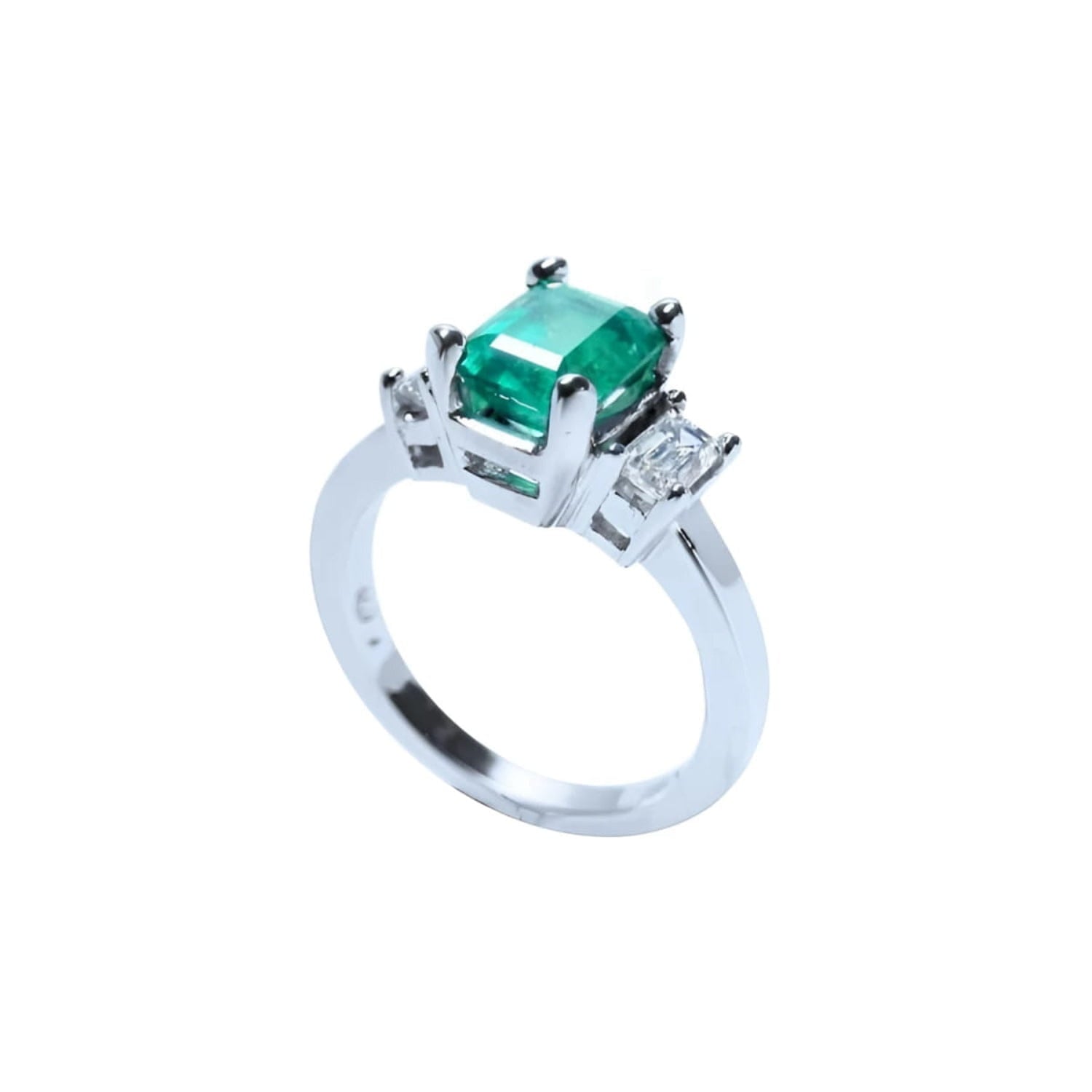 18K white gold three-stone emerald ring with a rectangular green emerald and two side emerald-cut diamonds.