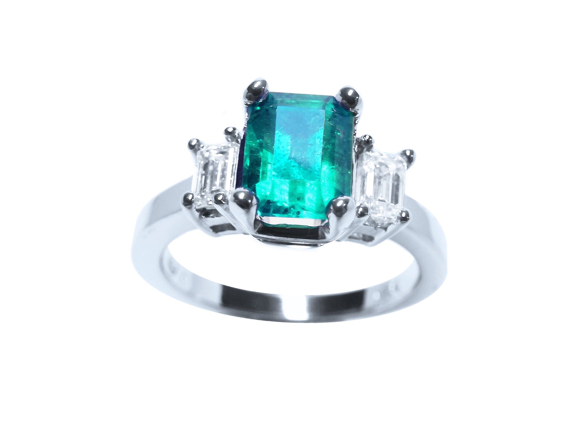 This three stone emerald engagement ring is placed on top position with both sides profila view.