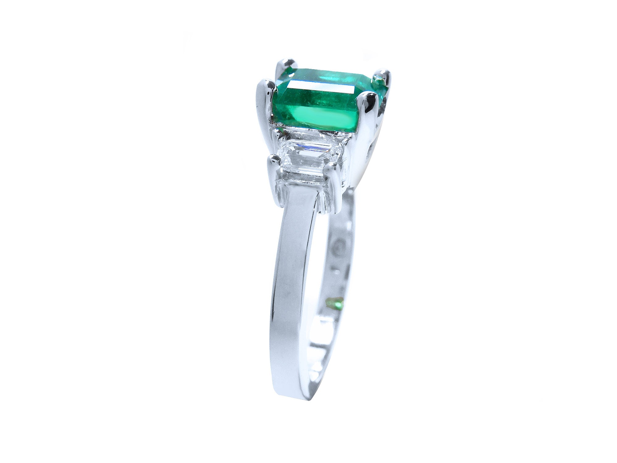 This three stone emerald and side diamonds engagement ring is displaying its top to downside profile.